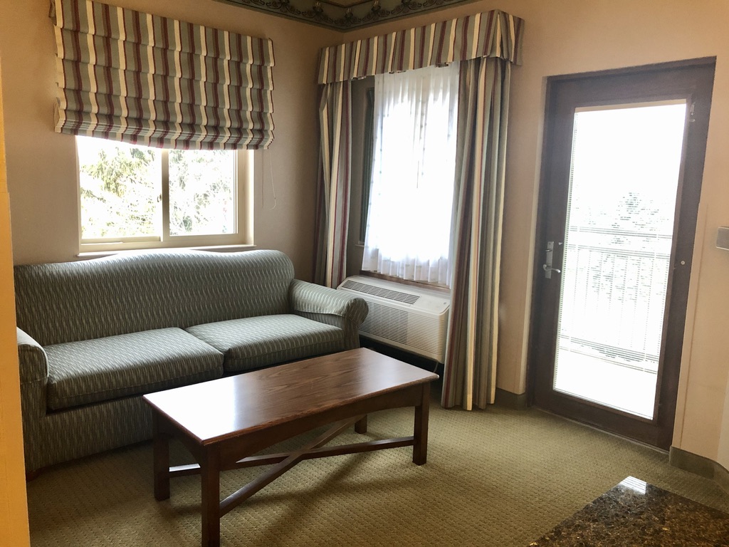Zehnder's Splash Village Family Suite cozy sitting area with sofa, coffee table, large flat screen TV, and fireplace.
