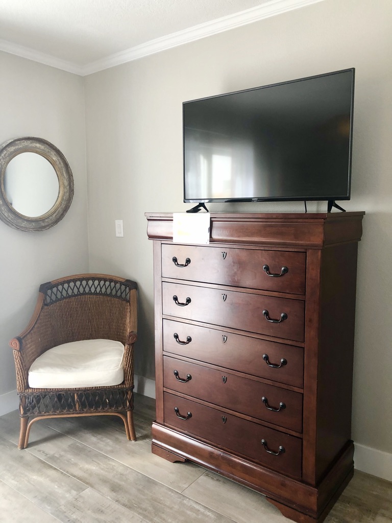 Master bedroom sitting area with dresser and tv.