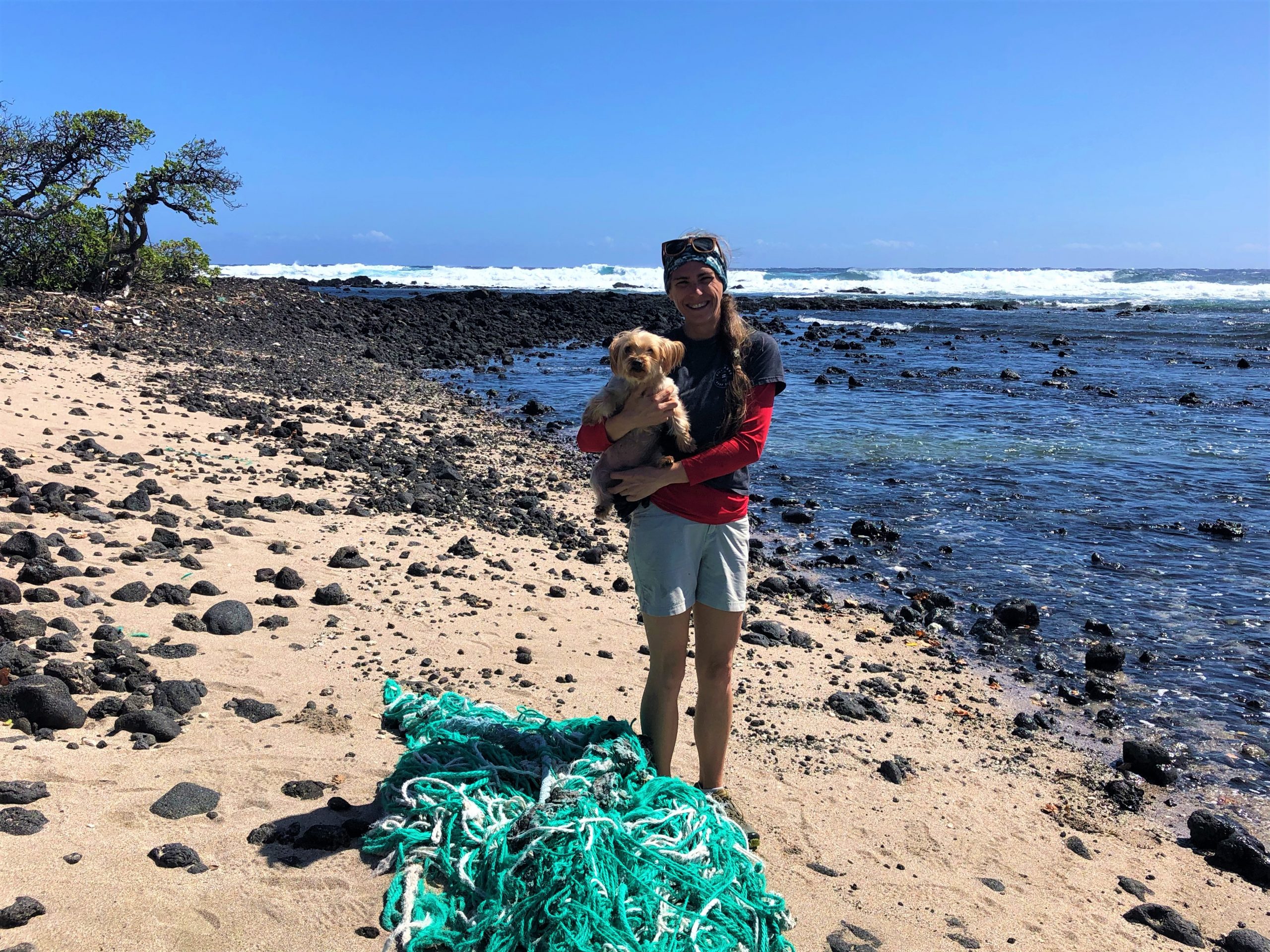 Mattie Mae of Upcycle Hawaii standing next to a ghost shore that has washed ashore on the Big Island. 