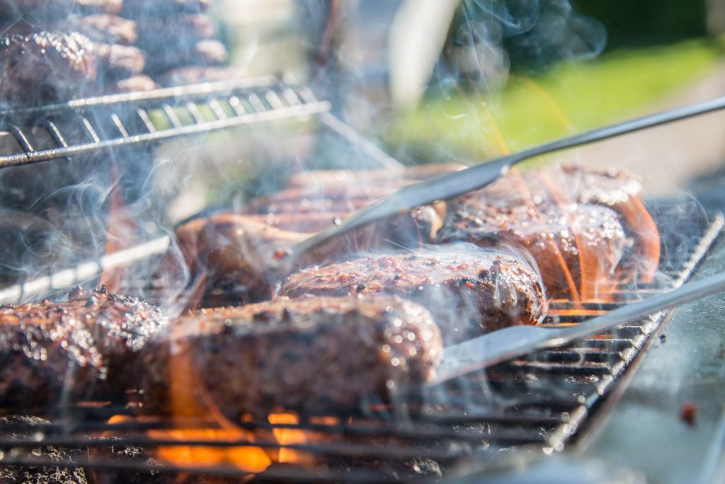 Hamburgers grilling on a grill.