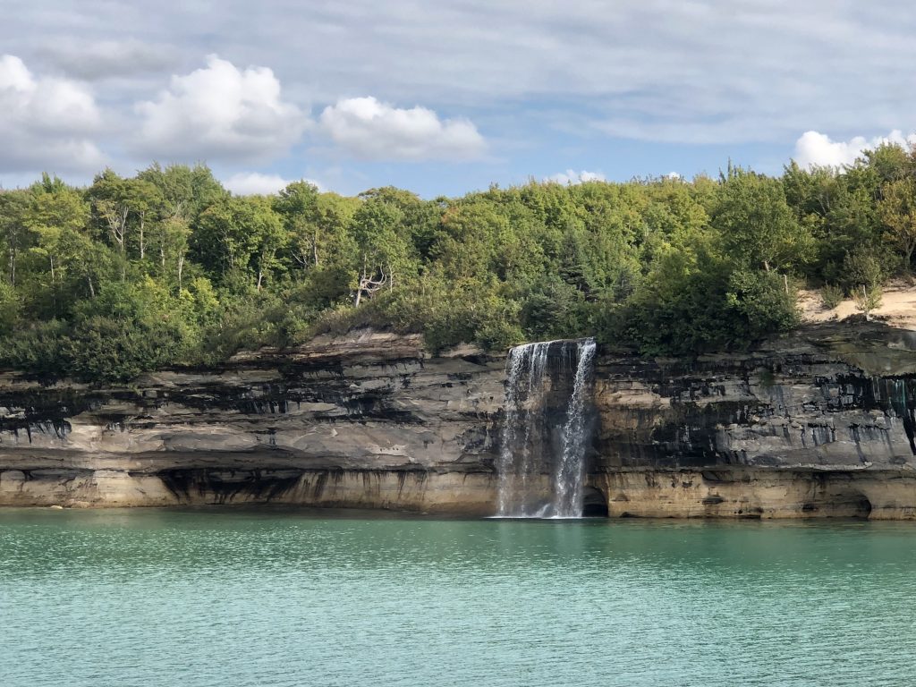 Spray Falls waterfall cascading over the edge of sandstone cliffs. 