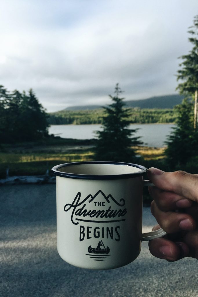 Coffee mug that says "The Adventure Begins." Multigenerational vacation tips - Just Do It!