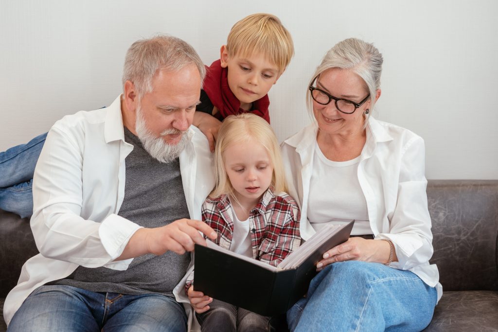 Family looking at photo album - Multigenerational vacation tips.