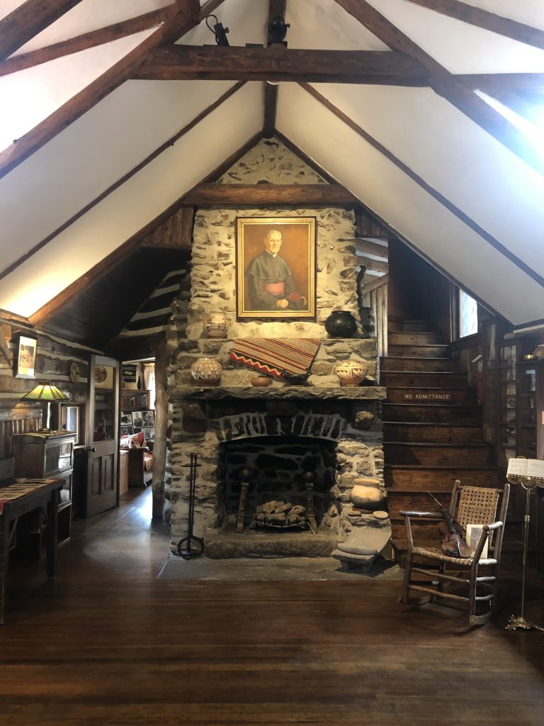 Living room with stone fireplace inside the Hiwan Museum, Evergreen CO